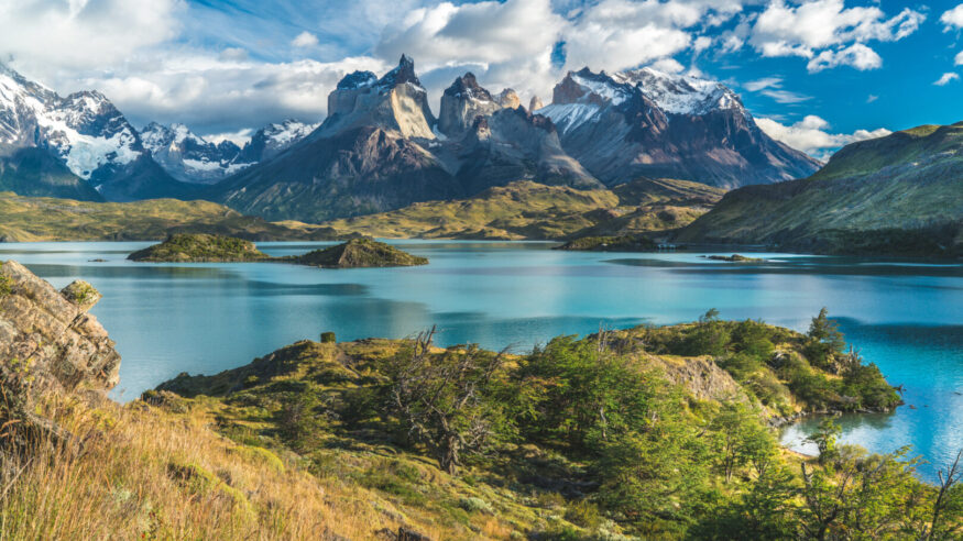 Blue lake on a snowy mountains background and cloudy sky Torres del paine
