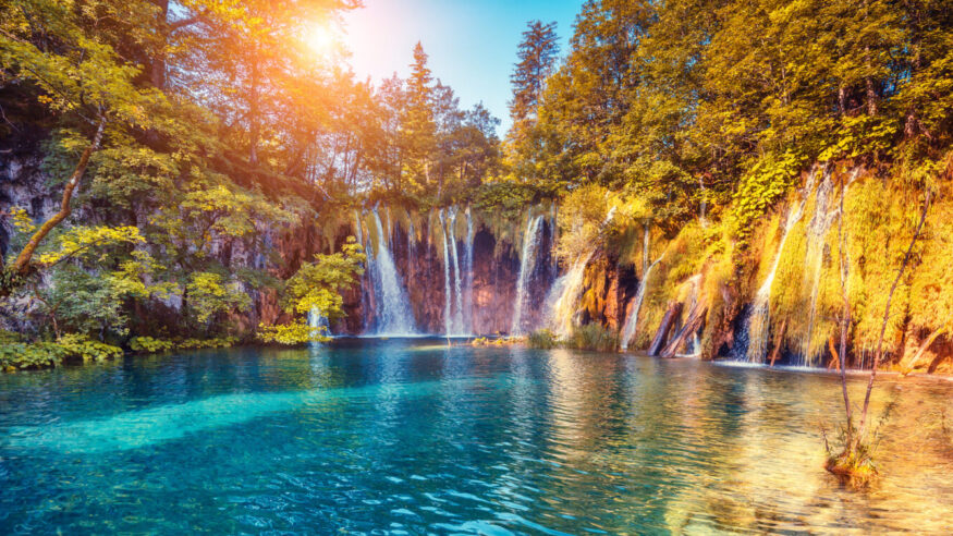 Majestic view on turquoise water and sunny beams in the Plitvice Lakes National Park. Croatia. Europe. Dramatic unusual scene. Beauty world. Retro filter and vintage style. Instagram toning effect.